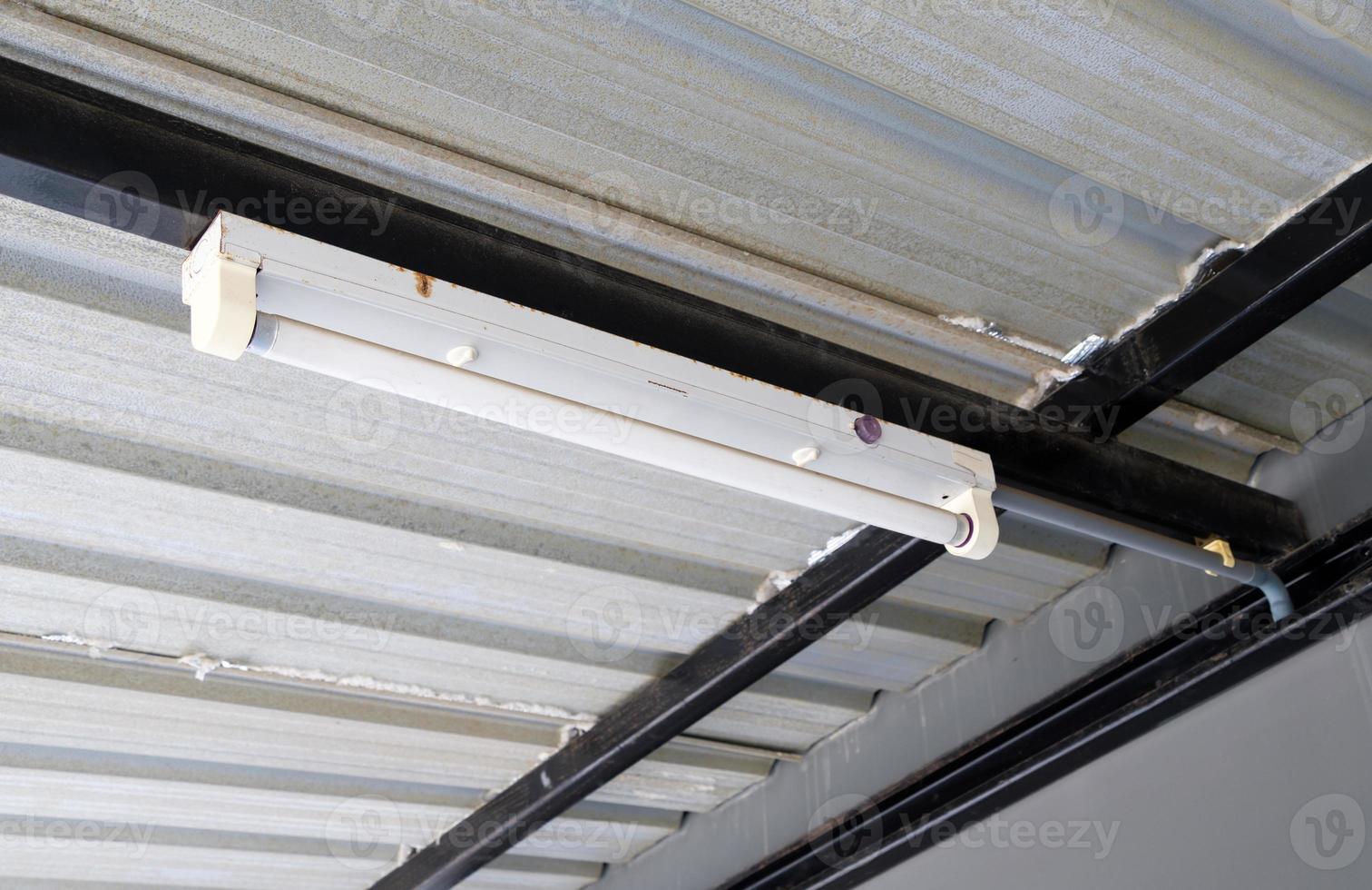 The fluorescent lamp is hanging on the metal frame. photo