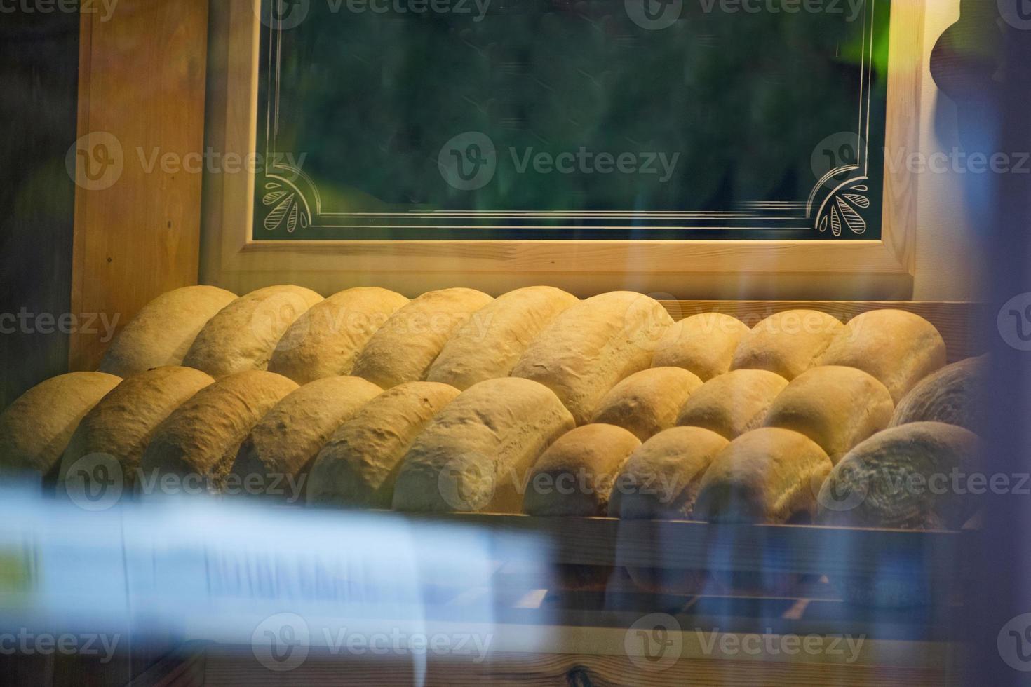 Baked bread in a bakery window display. Baked bread closeup in a typical confectionery shop photo