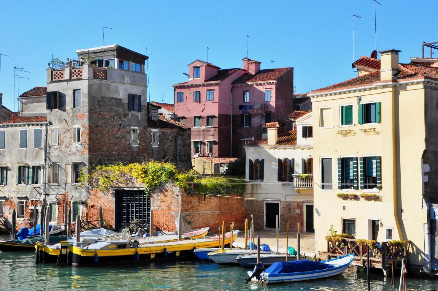 parte no turística de venecia con silencio vacío edificios coloridos, ventanas, calles y barcos foto