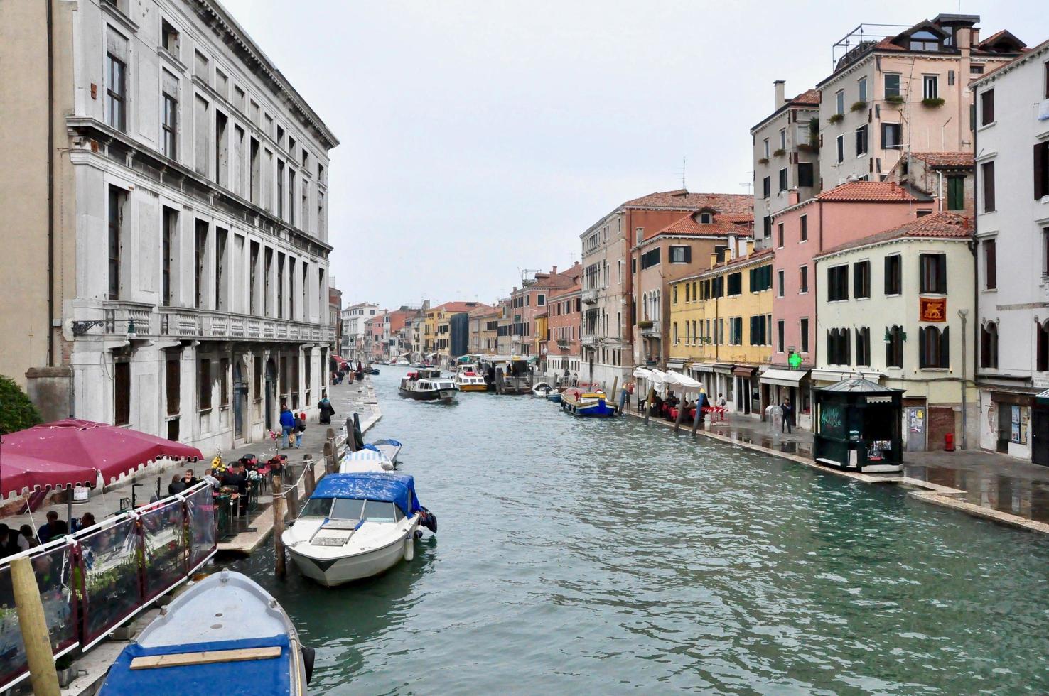 Classic Venice channel view with typical buildings, colorful windows, bridges and boats photo