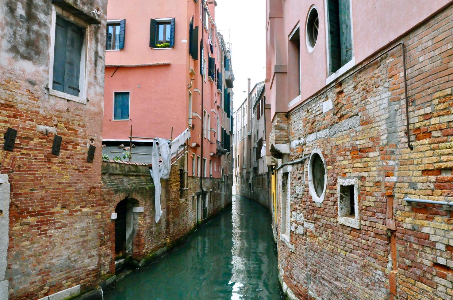 Classic Venice channel view with typical buildings, colorful windows, bridges and boats photo