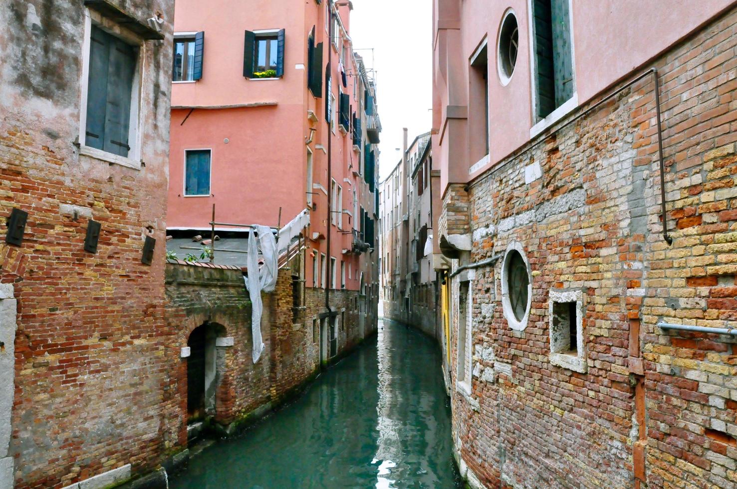 vista clásica del canal de Venecia con edificios típicos, ventanas coloridas, puentes y barcos foto