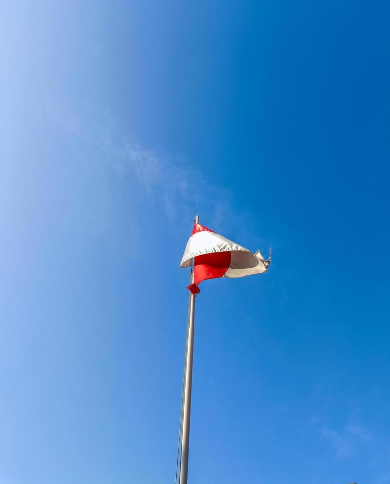 la bandera roja y blanca ondea en el cielo contra el fondo azul del cielo foto