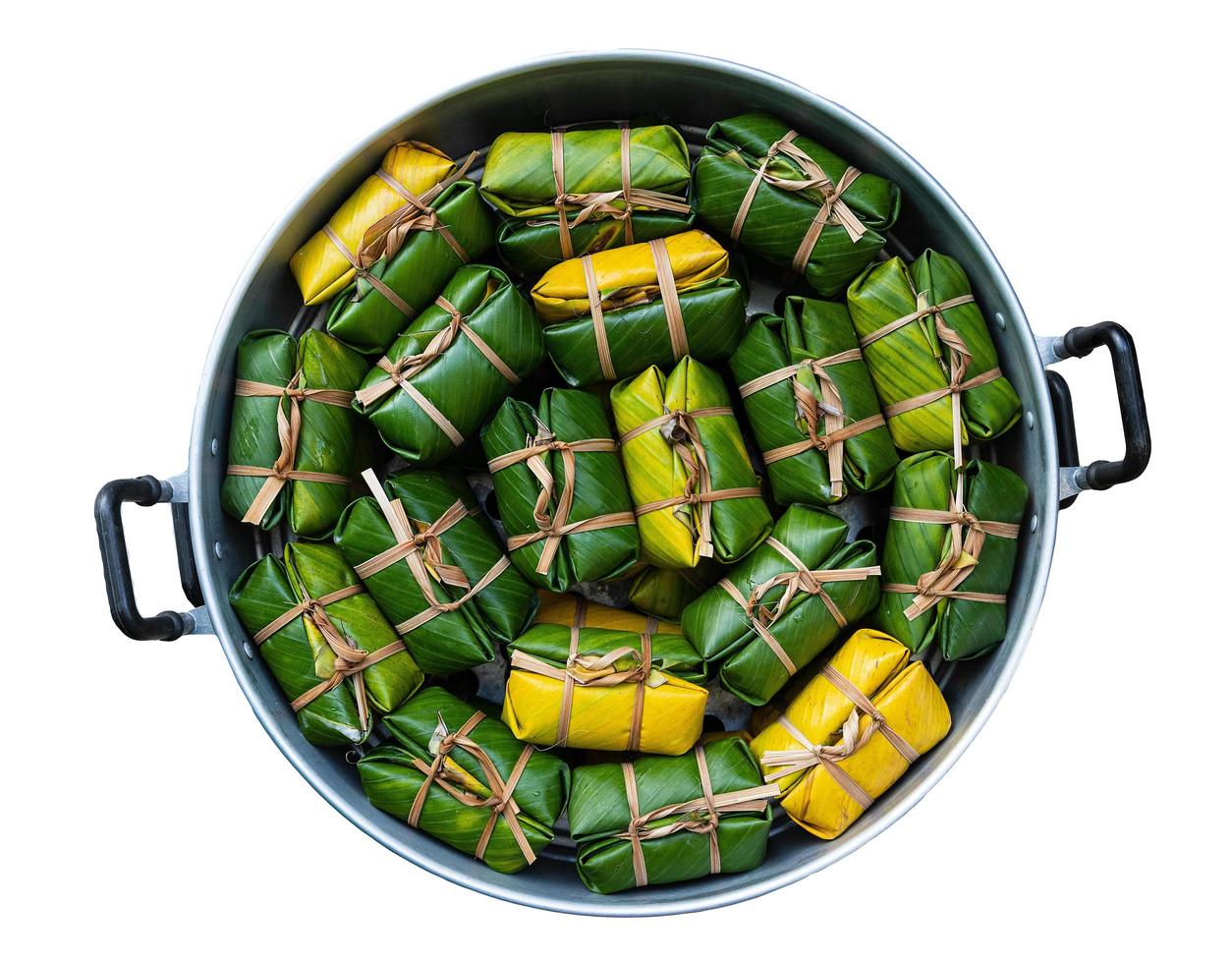 Khao Tom Mud, popular Thai traditional dessert, made from ripe bananas, glutinous rice, sugar, and coconut milk, wrapped in fresh banana leaves and tied with string made from plant rinds. photo