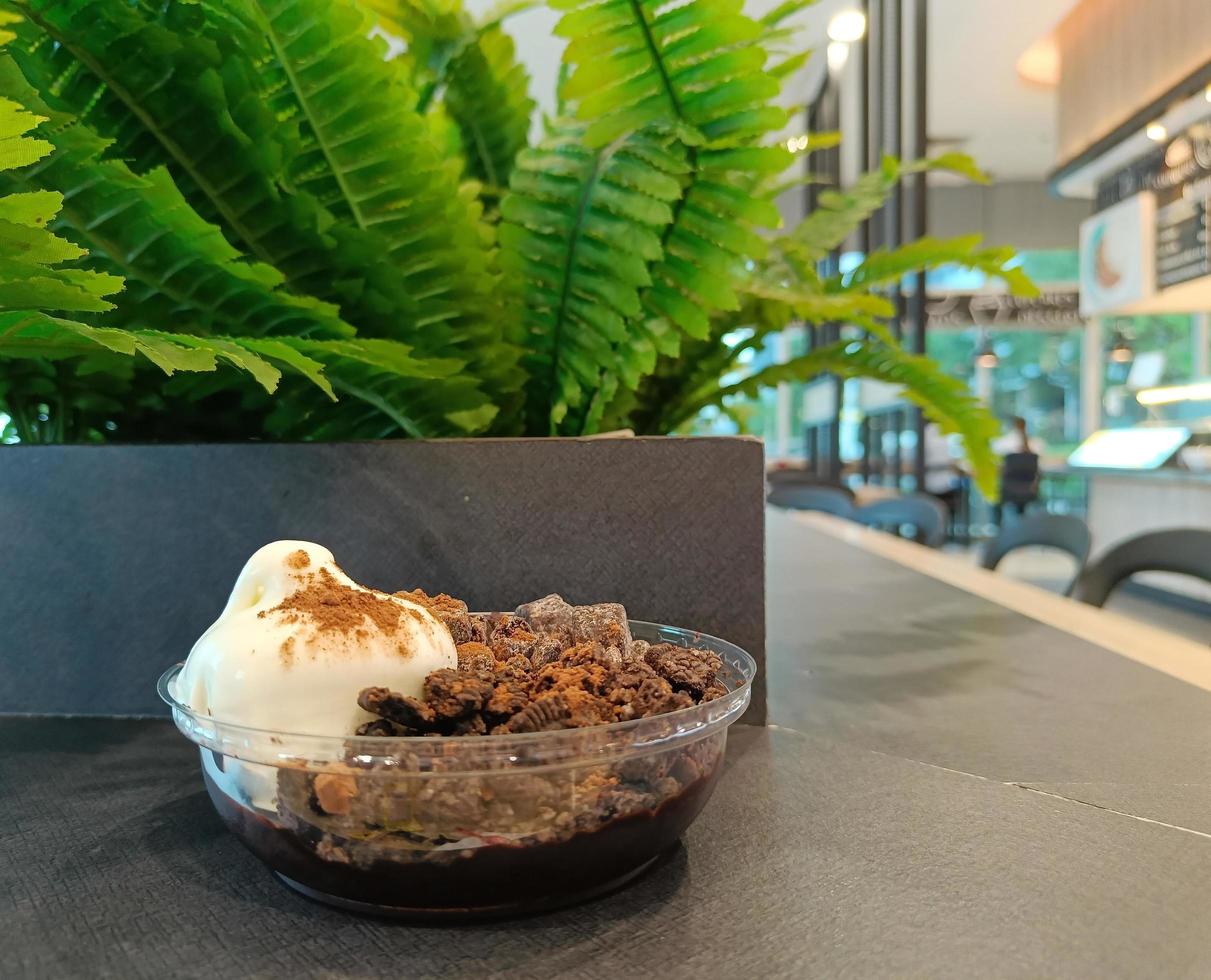 Sundae de helado de vainilla con cobertura de brownies de galleta crema de chocolate fondo desenfocado foto