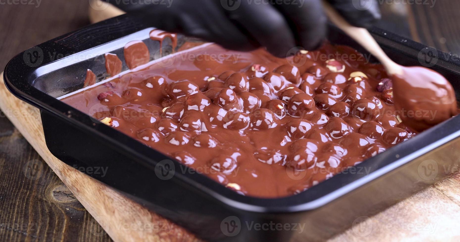 making chocolate from high-quality cocoa and cocoa butter with hazelnuts photo