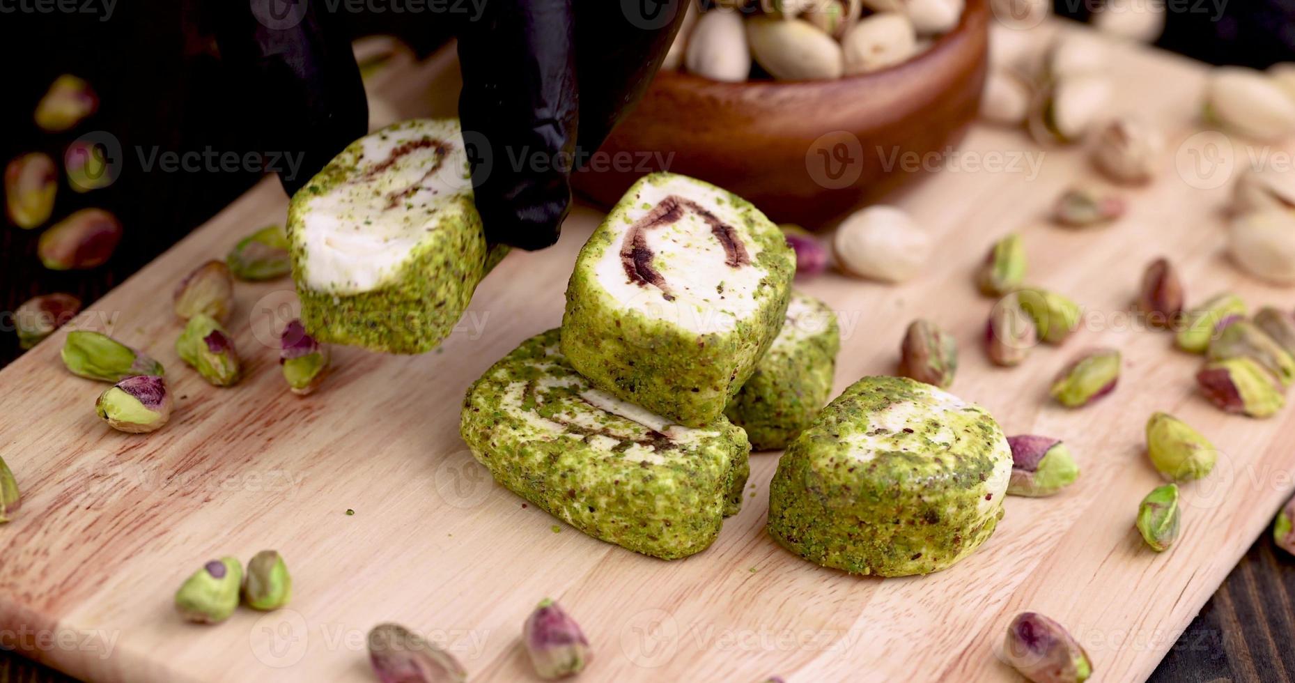 poner delicias turcas frescas con pistachos triturados y chocolate en una tabla foto