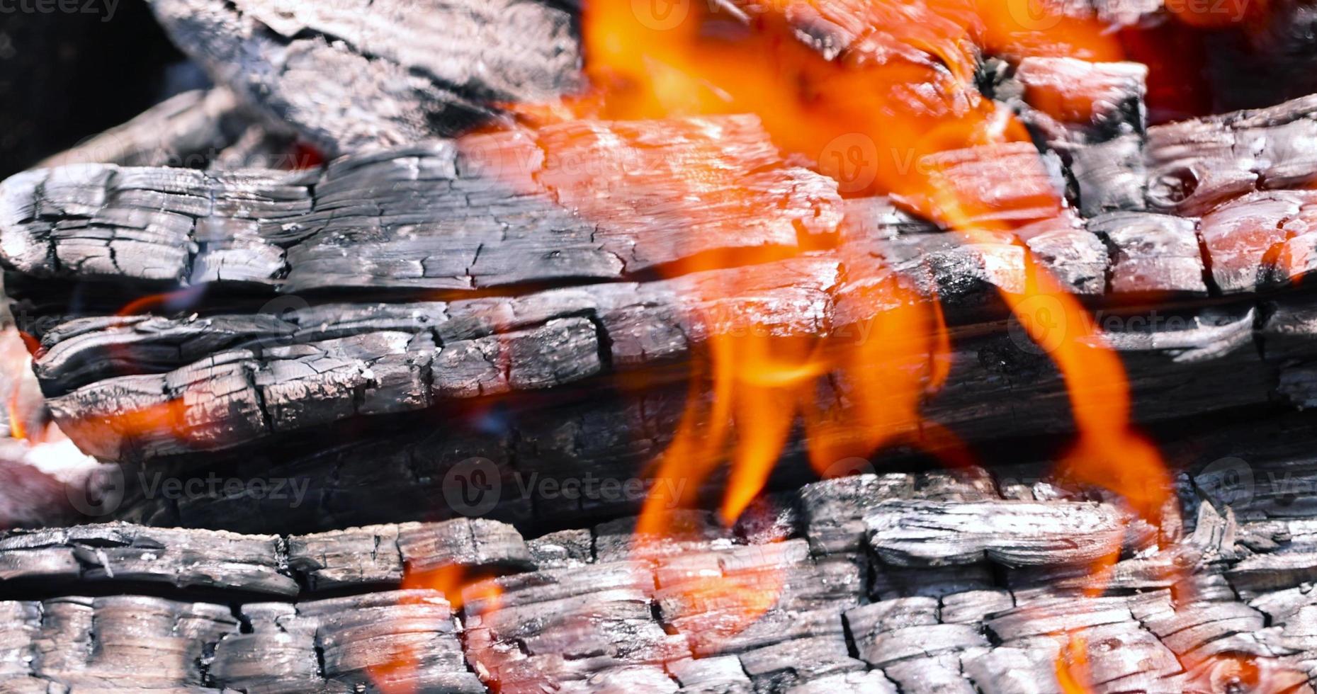 Burning logs in a campfire while cooking and warming photo