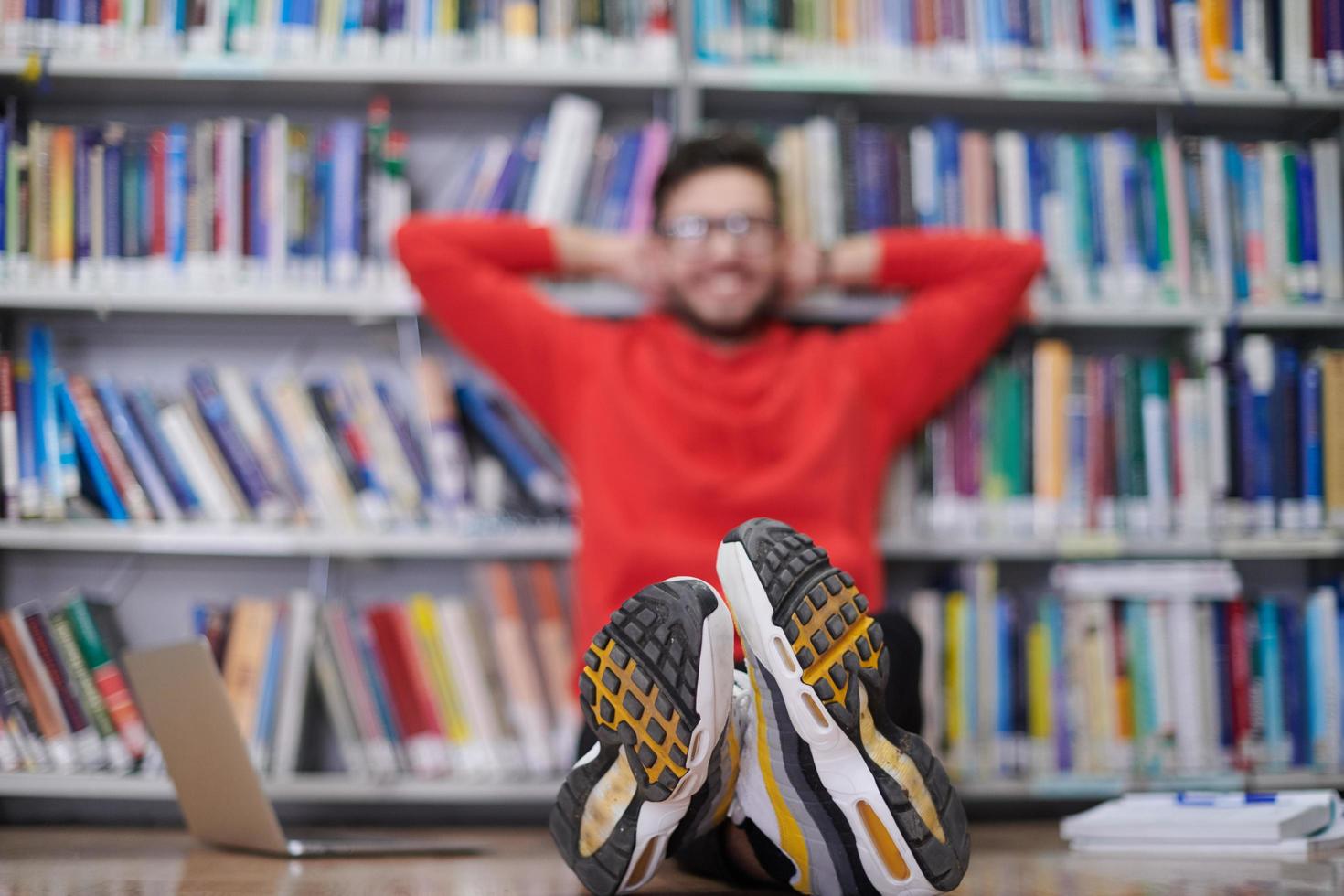 the students uses a notebook, laptop and a school library photo