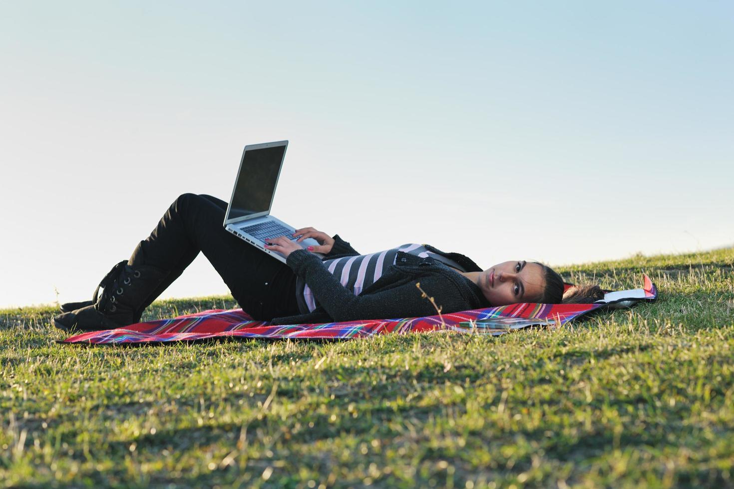 Joven adolescente trabaja en una laptop al aire libre foto