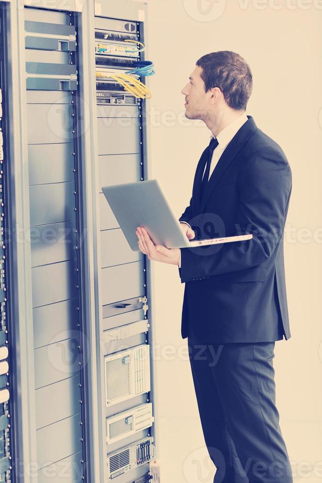 businessman with laptop in network server room photo