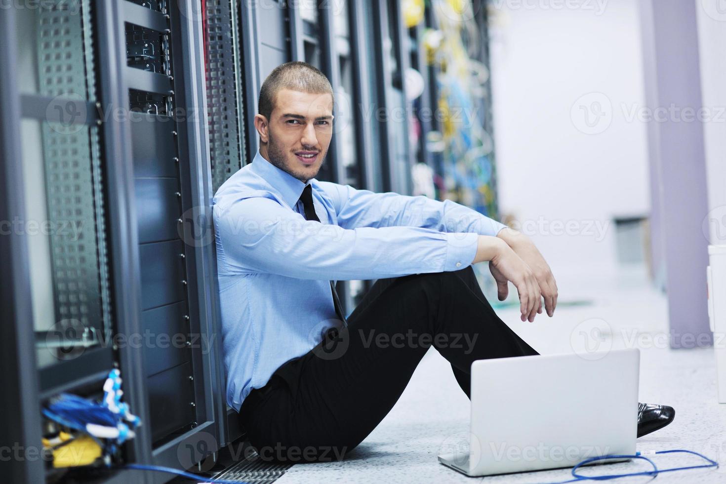 businessman with laptop in network server room photo