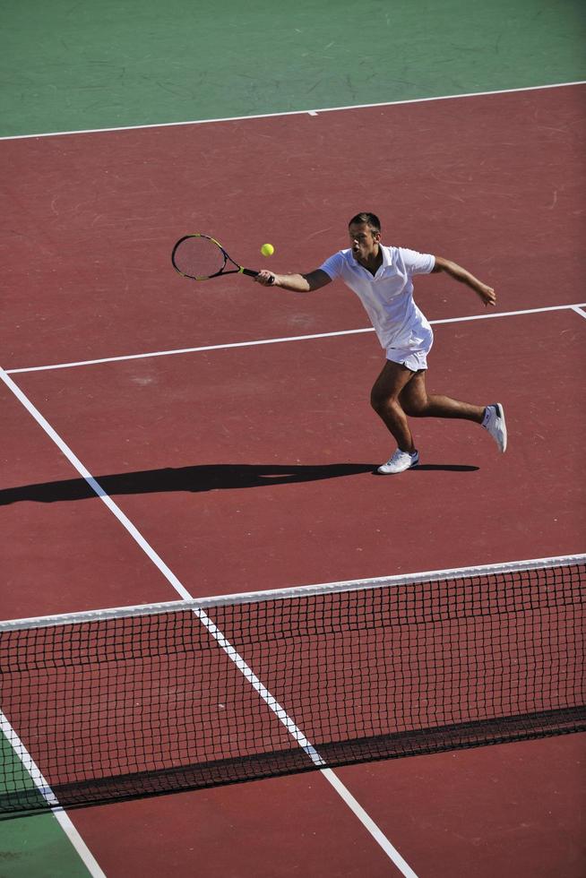 joven jugar al tenis al aire libre foto