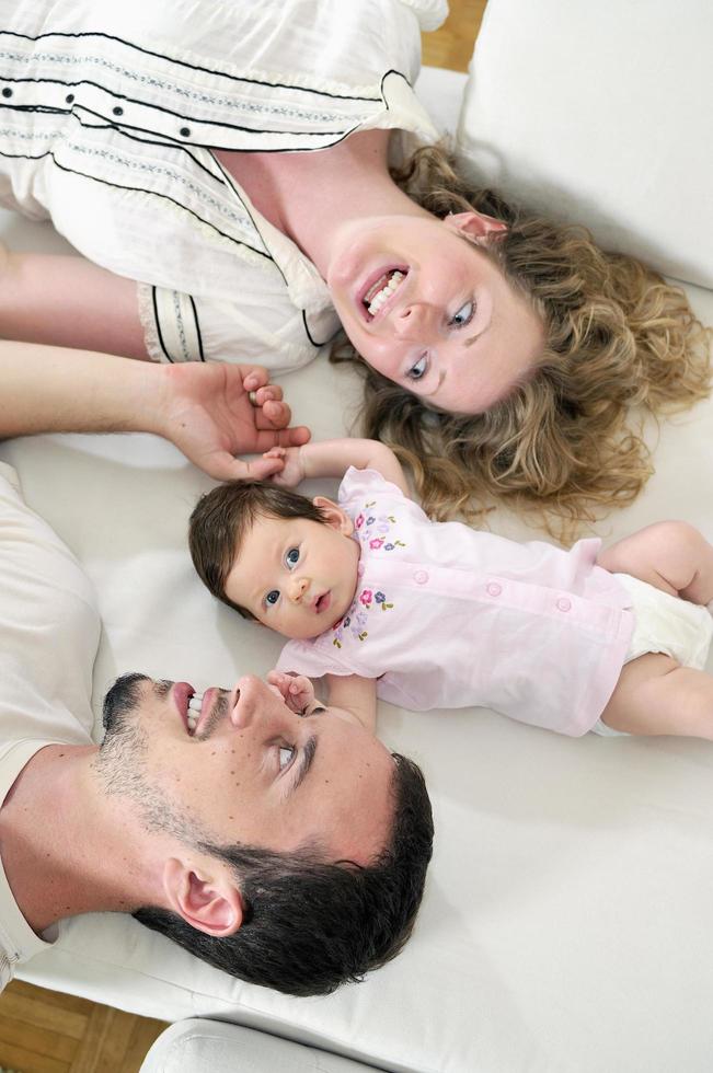 retrato interior con una familia joven feliz y un lindo bebé foto