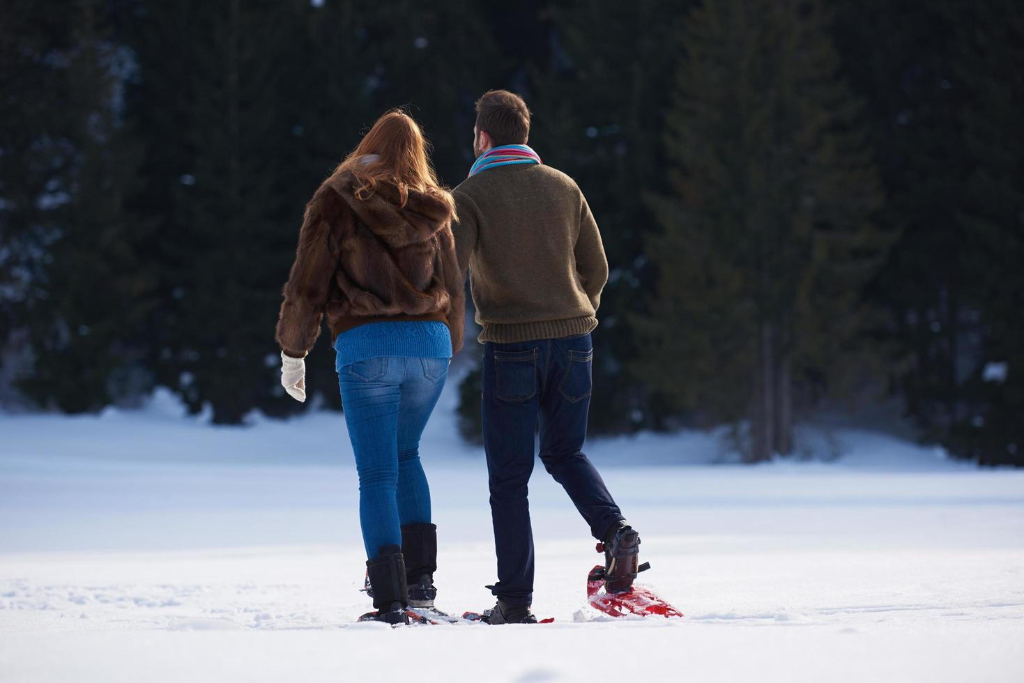 couple having fun and walking in snow shoes photo