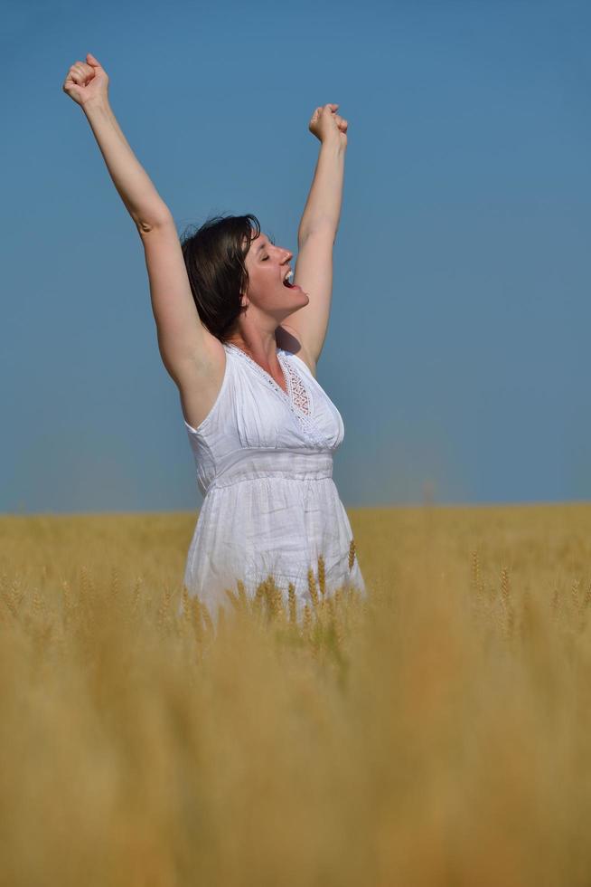 mujer joven en campo de trigo en verano foto