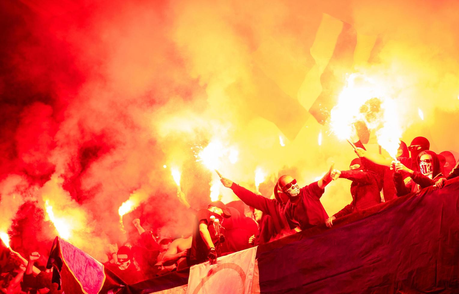 football hooligans with mask holding torches in fire photo