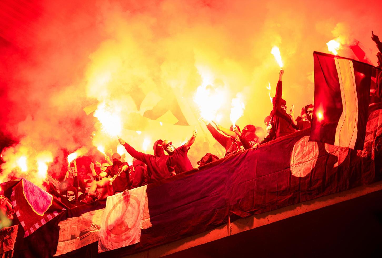 vándalos de fútbol con máscara sosteniendo antorchas en llamas foto