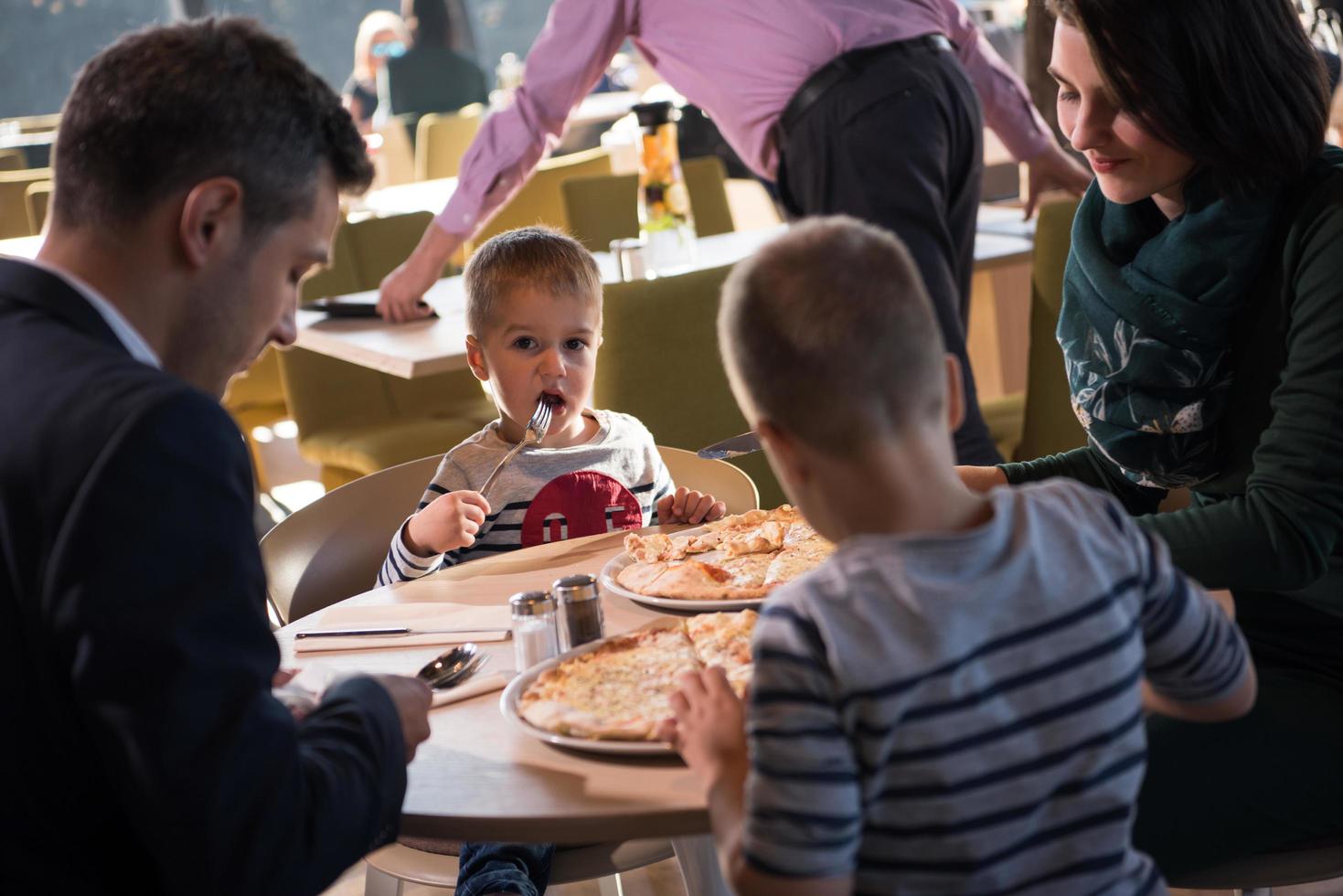 Young parents enjoying lunch time with their children photo