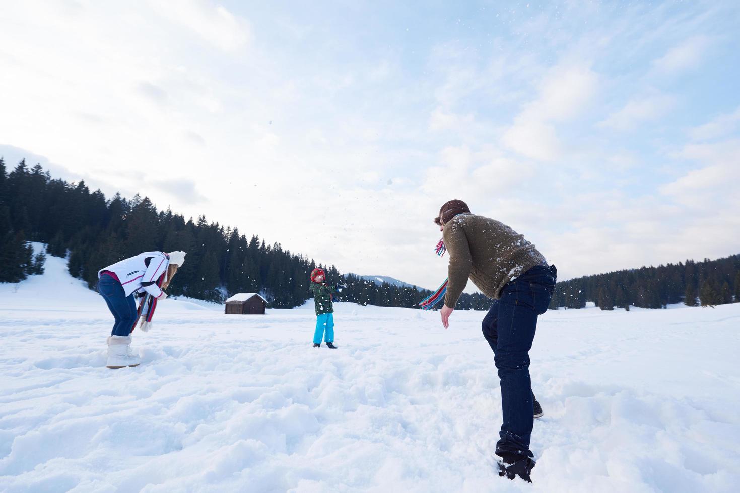 familia feliz jugando juntos en la nieve en invierno foto