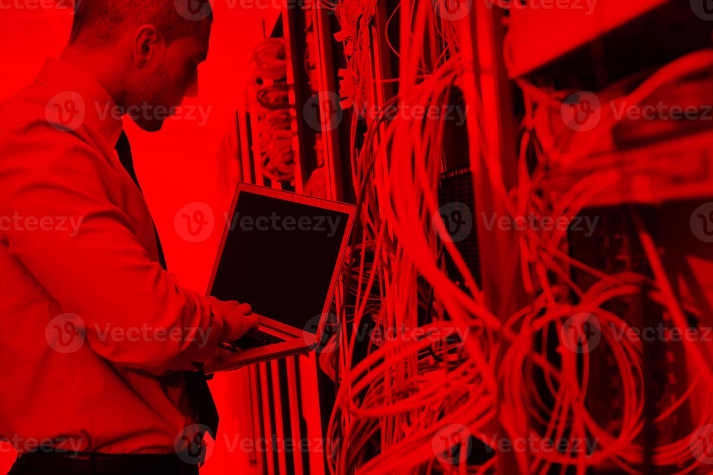 businessman with laptop in network server room photo