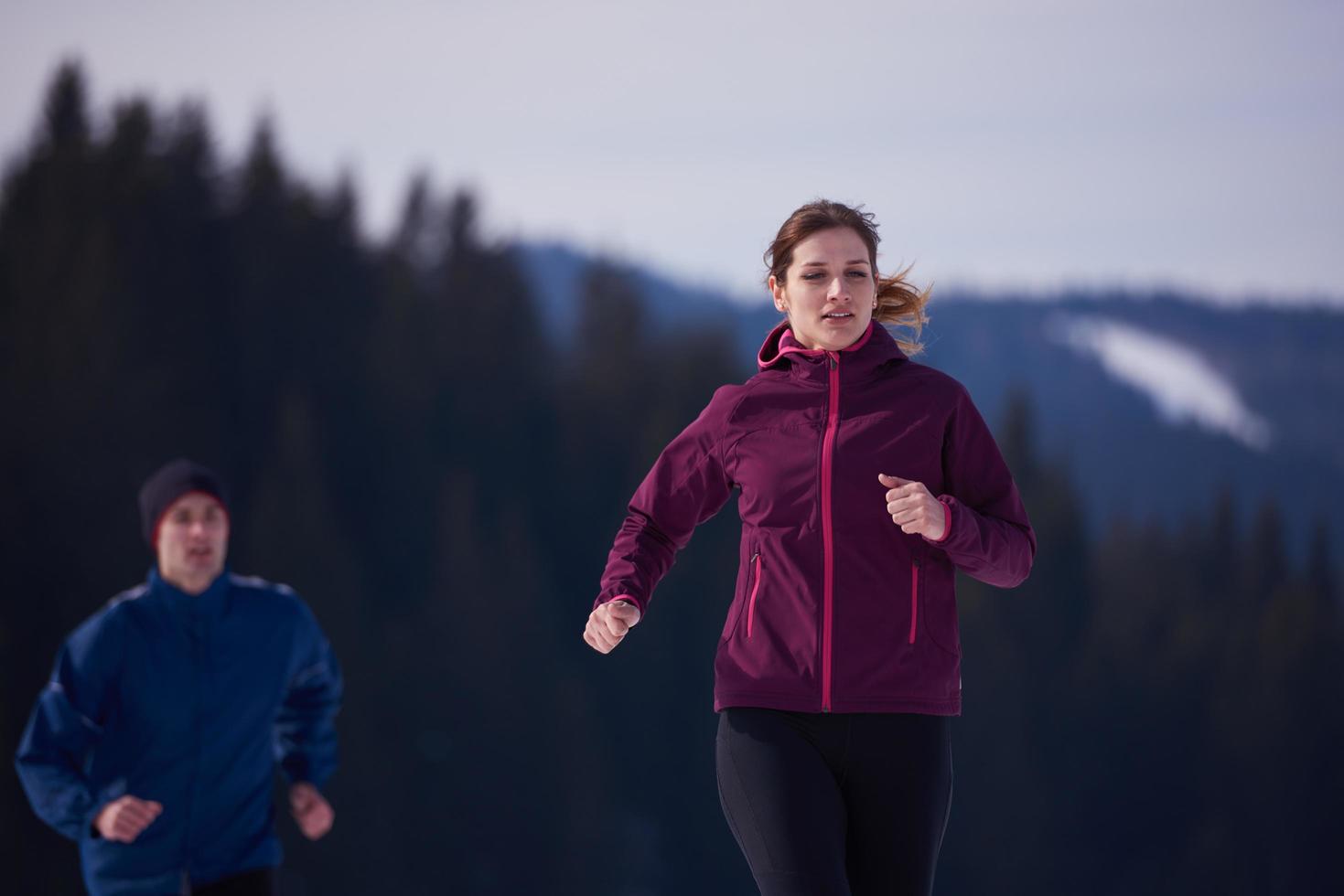 couple jogging outside on snow photo