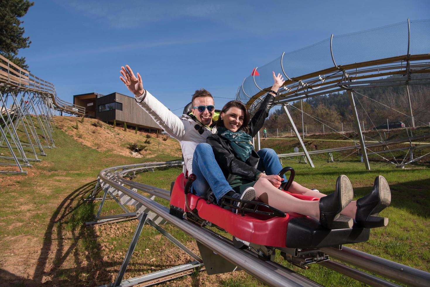 couple enjoys driving on alpine coaster photo