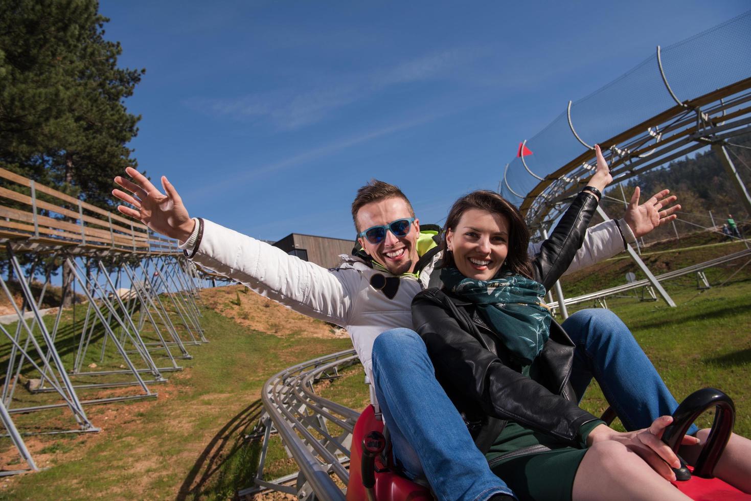 couple enjoys driving on alpine coaster photo