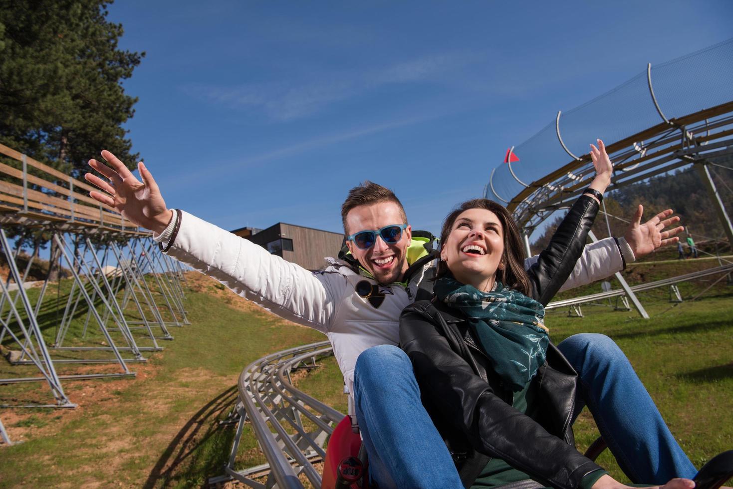 couple enjoys driving on alpine coaster photo