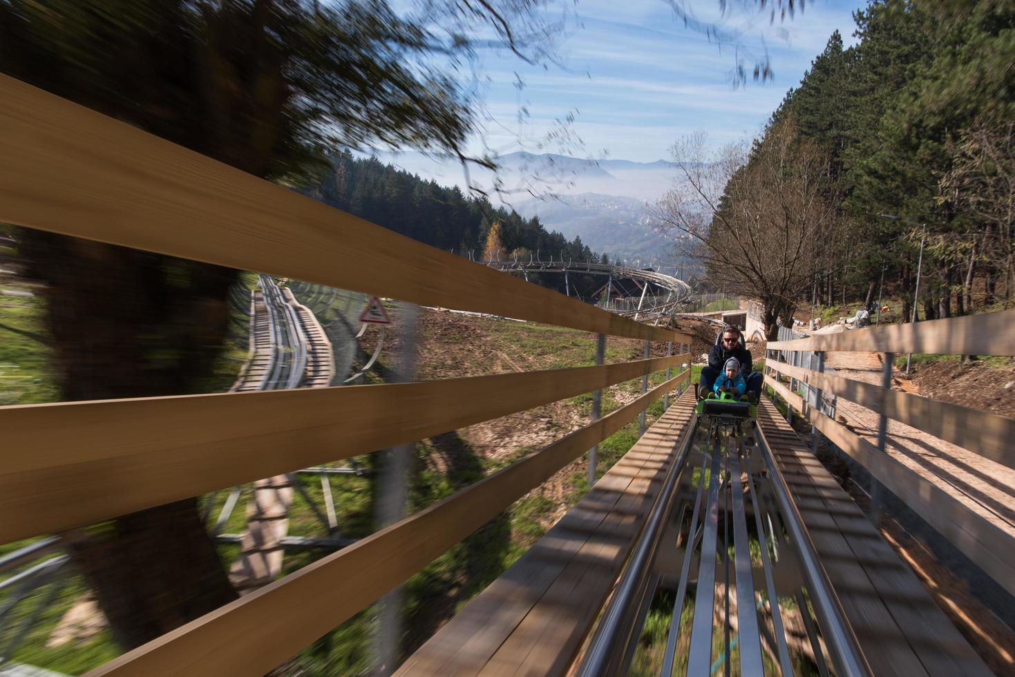 father and son enjoys driving on alpine coaster photo