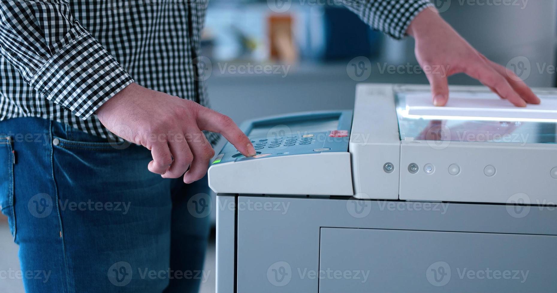 Male Assistant Using Copy Machine in modern office photo