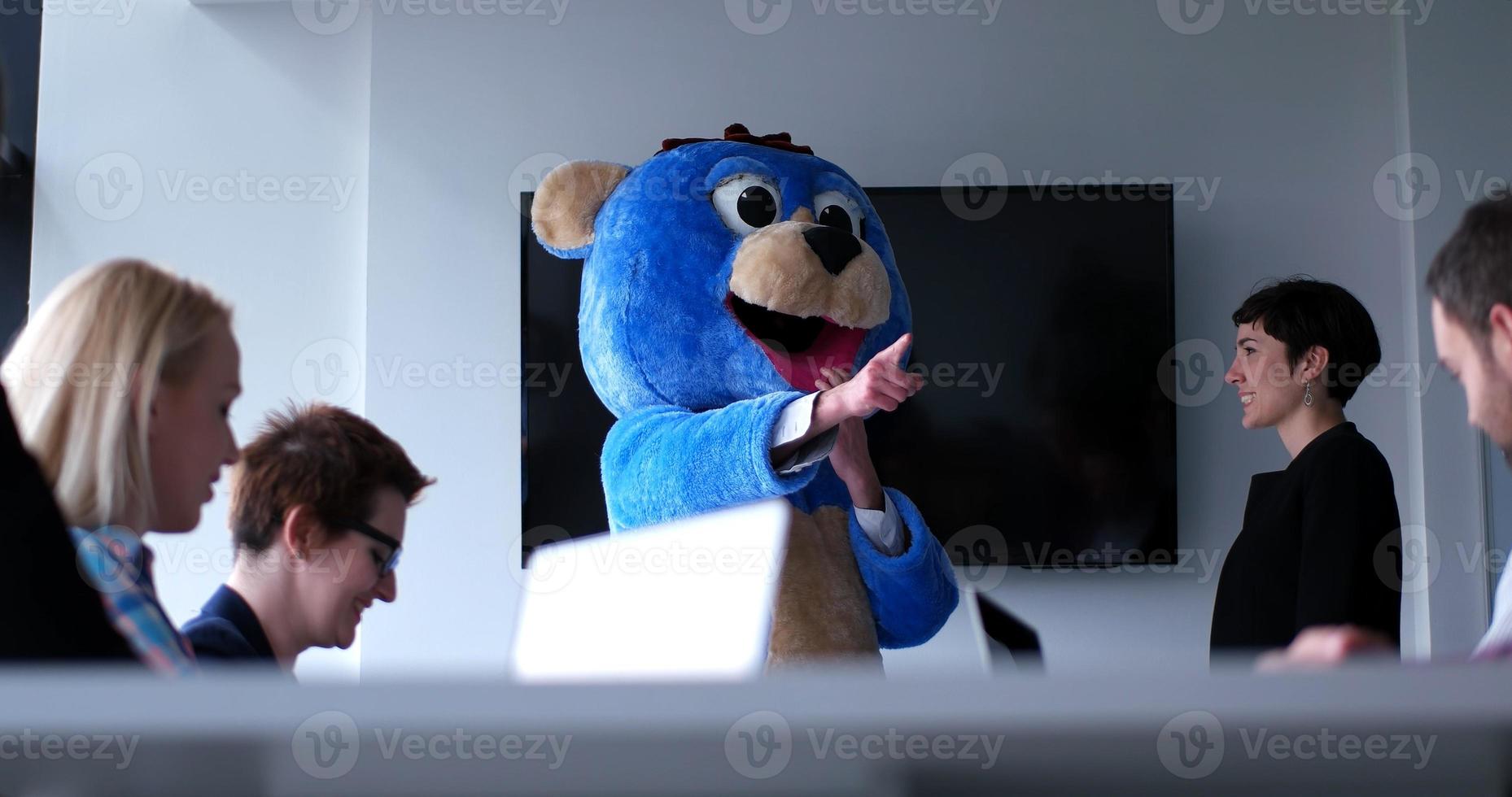 boss dresed as bear having fun with business people in trendy office photo