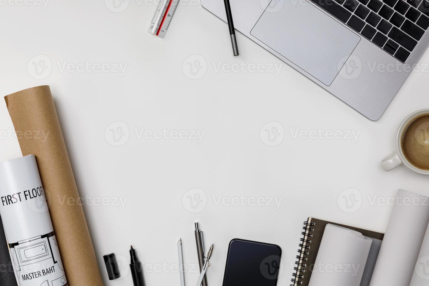 Top view workspace mockup of architectural project with laptop computer, roll blueprints, architectural project plan, engineering tools, office supplies and hot coffee cup on white desk empty space photo