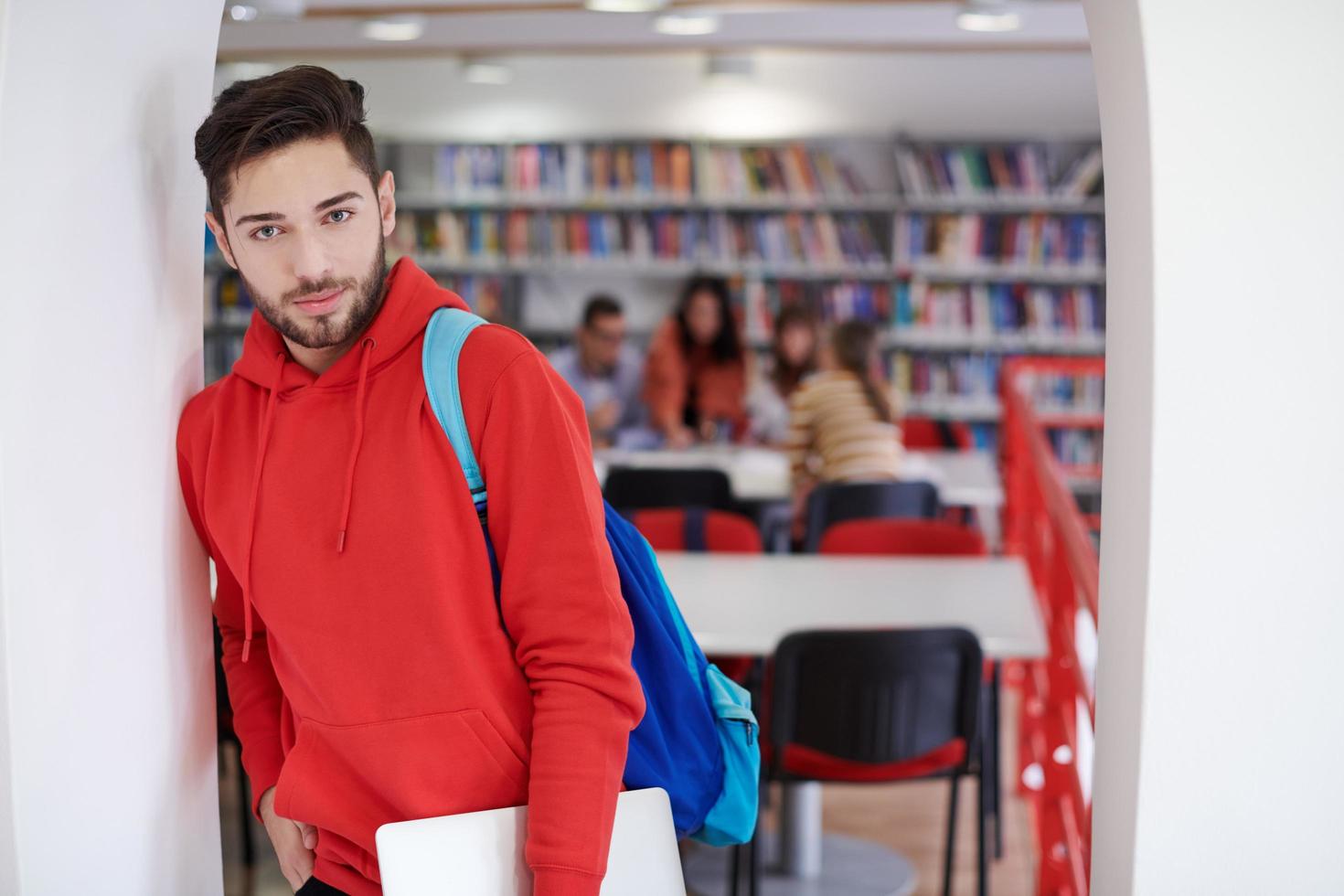 el estudiante usa una computadora portátil y una biblioteca escolar foto