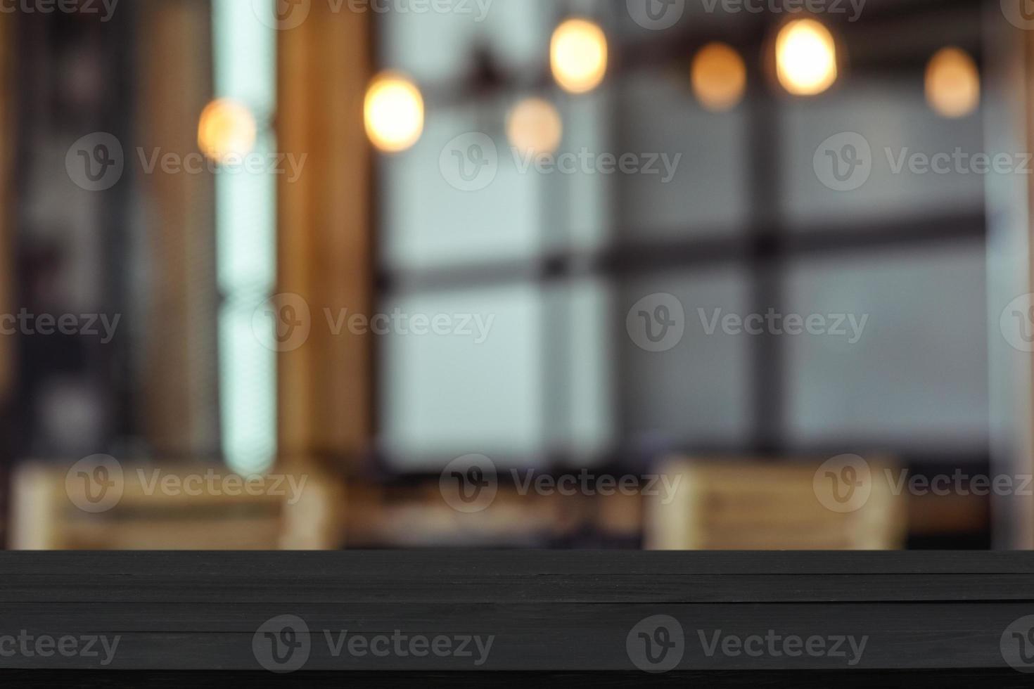 Empty wooden table top with view of room or wooden desk with restaurants with blur background, copy space for your text photo