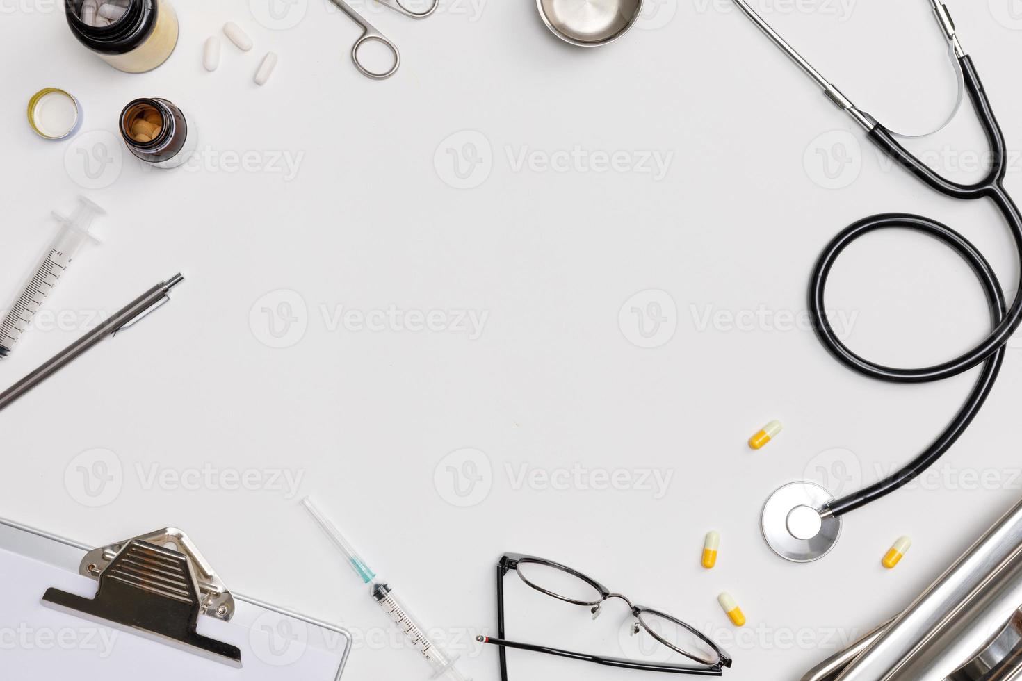 flatlay creativo de mesa blanca de equipo médico médico con estetoscopio, documentos médicos, termómetro, jeringa y pastillas, concepto de atención médica, vista superior con espacio de copia, aislado en blanco foto