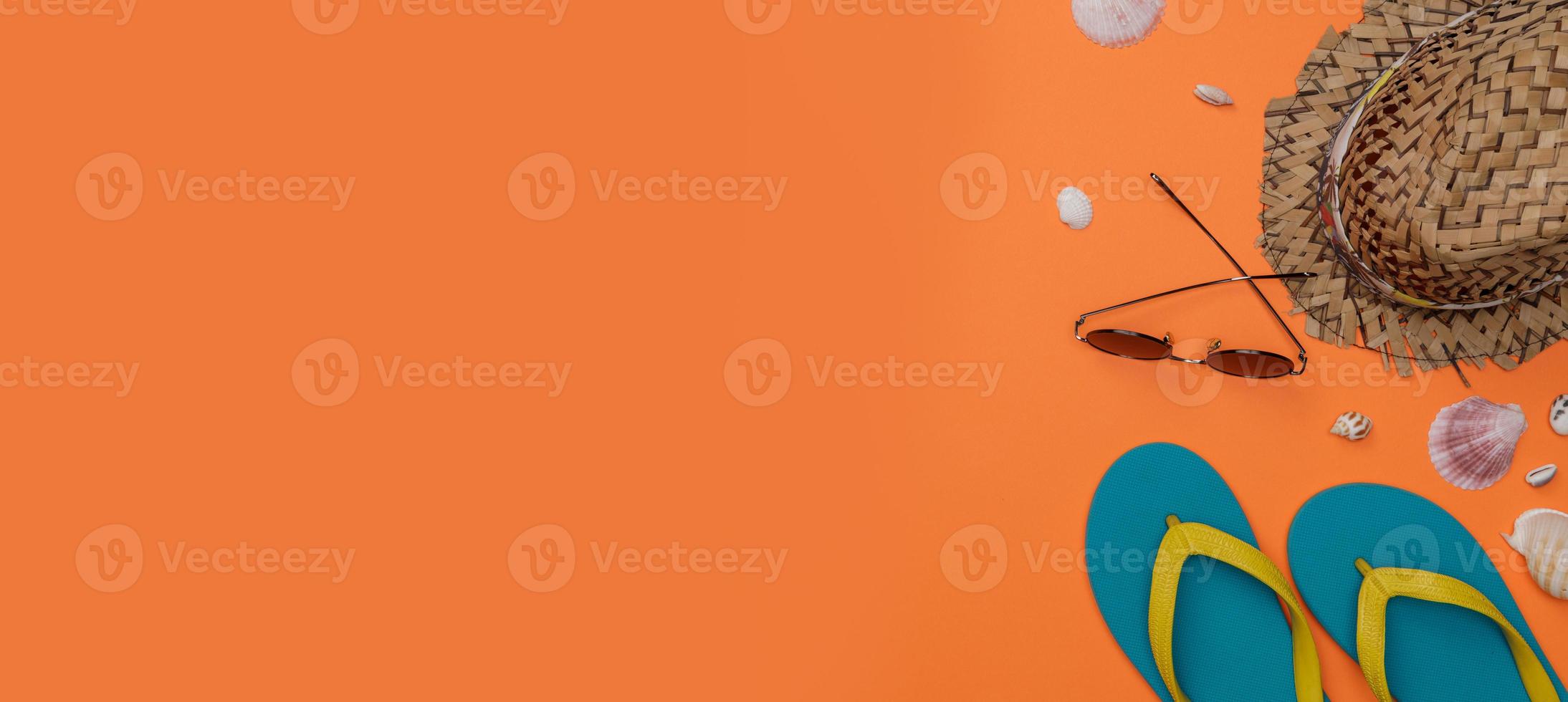 Traveler's accessories with sun glasses, shellfish, slippers, hat, long banner isolated orange background, Overhead view with copy space, Tropical travel concept photo