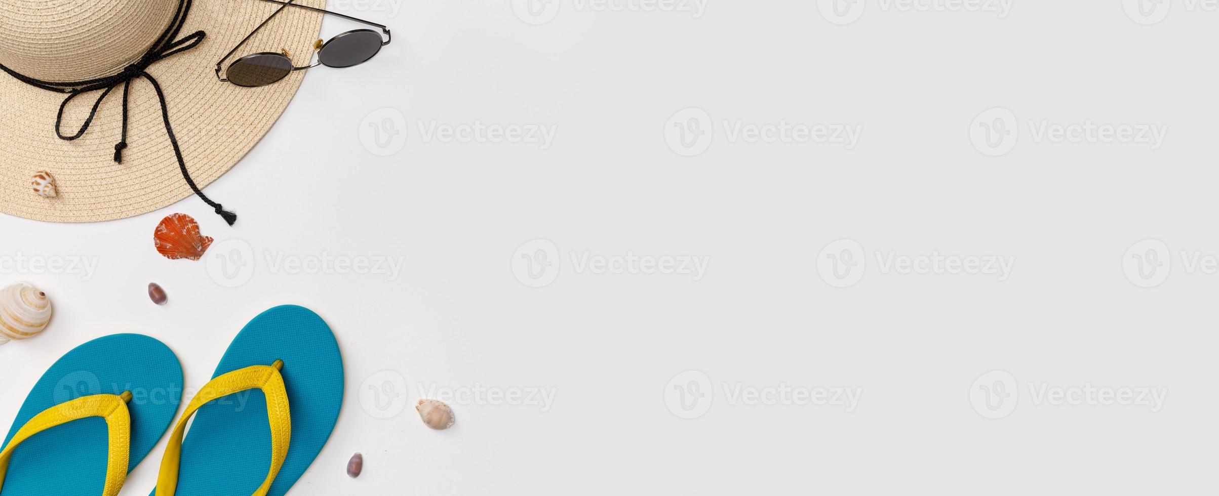 accesorios de viajero con mariscos, zapatillas, gafas de sol y sombrero de fondo blanco aislado, vista superior con espacio de copia, concepto de viaje tropical foto