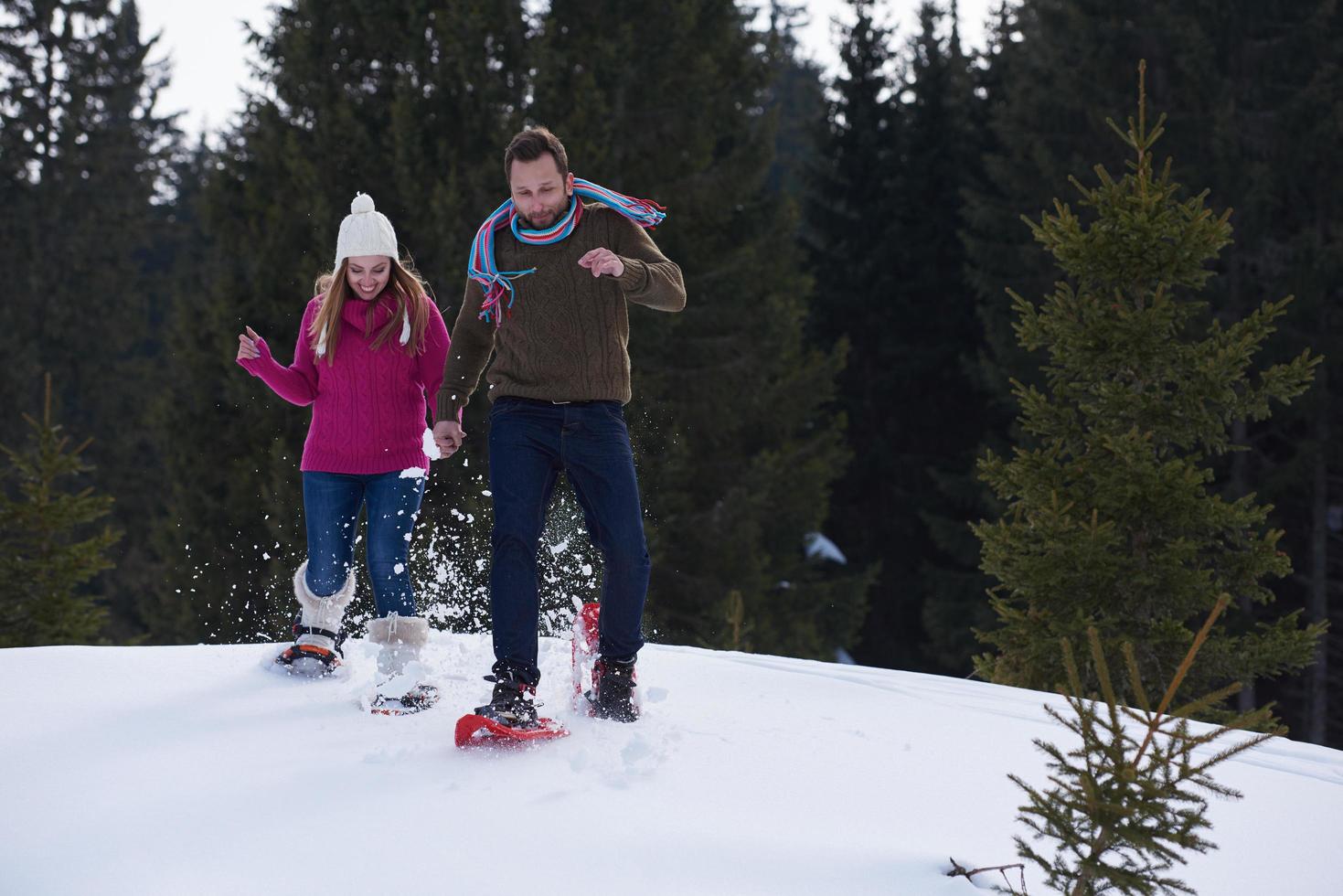 couple having fun and walking in snow shoes photo