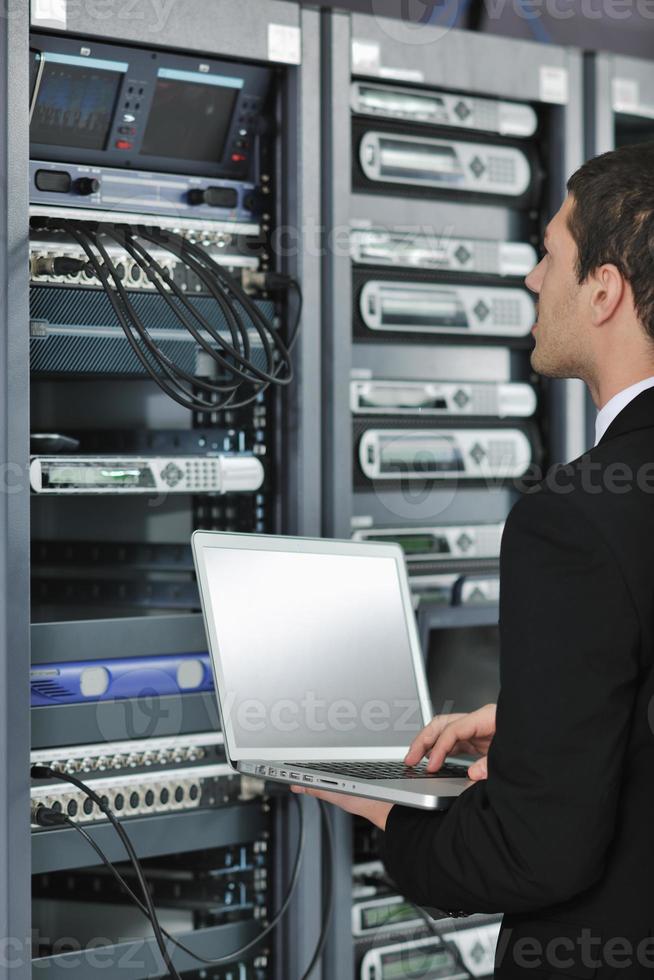 businessman with laptop in network server room photo