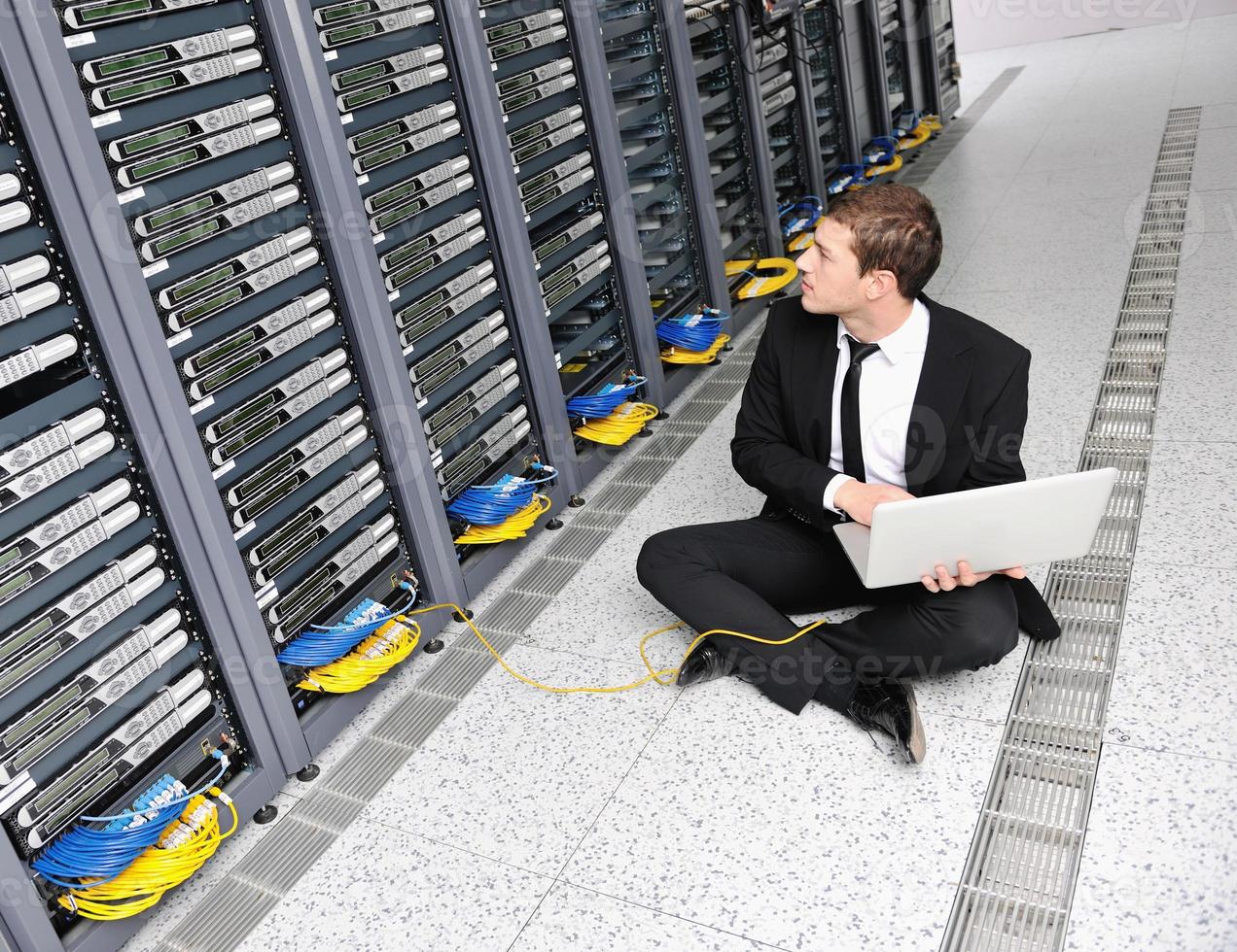 businessman with laptop in network server room photo