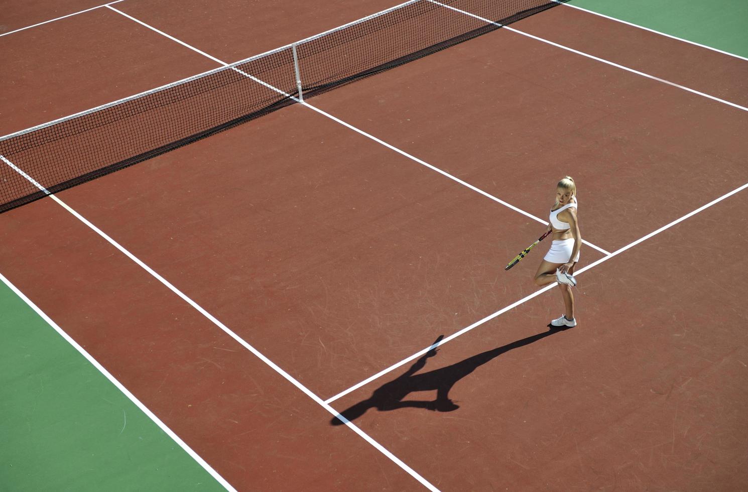 mujer joven jugar al tenis al aire libre foto