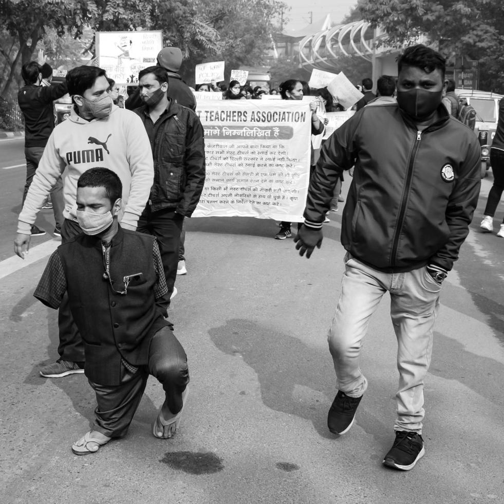 Delhi, India December 25 2021 - Delhi Contractual Guest Teachers with posters, flags and graffitis protesting against Delhi AAP Government for making policy, Delhi Teacher protesting Black and White photo
