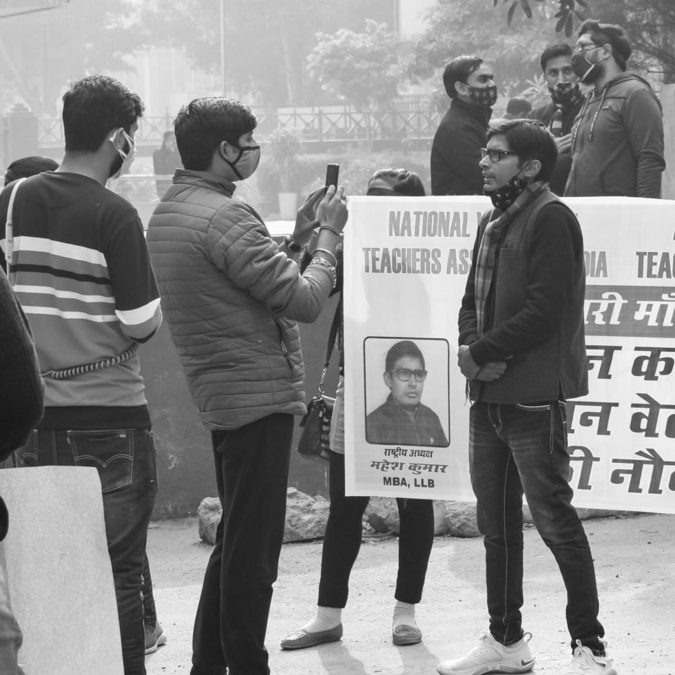 Delhi, India December 25 2021 - Delhi Contractual Guest Teachers with posters, flags and graffitis protesting against Delhi AAP Government for making policy, Delhi Teacher protesting Black and White photo