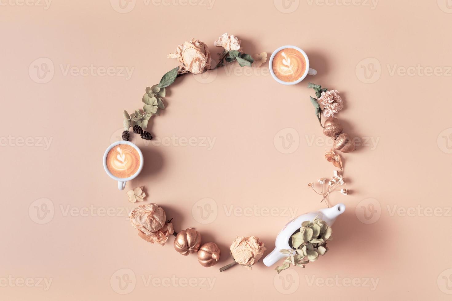 Autumn composition. Wreath made of dried leaves and coffee cups on pastel beige background. Autumn, fall concept. Flat lay, top view, copy space photo