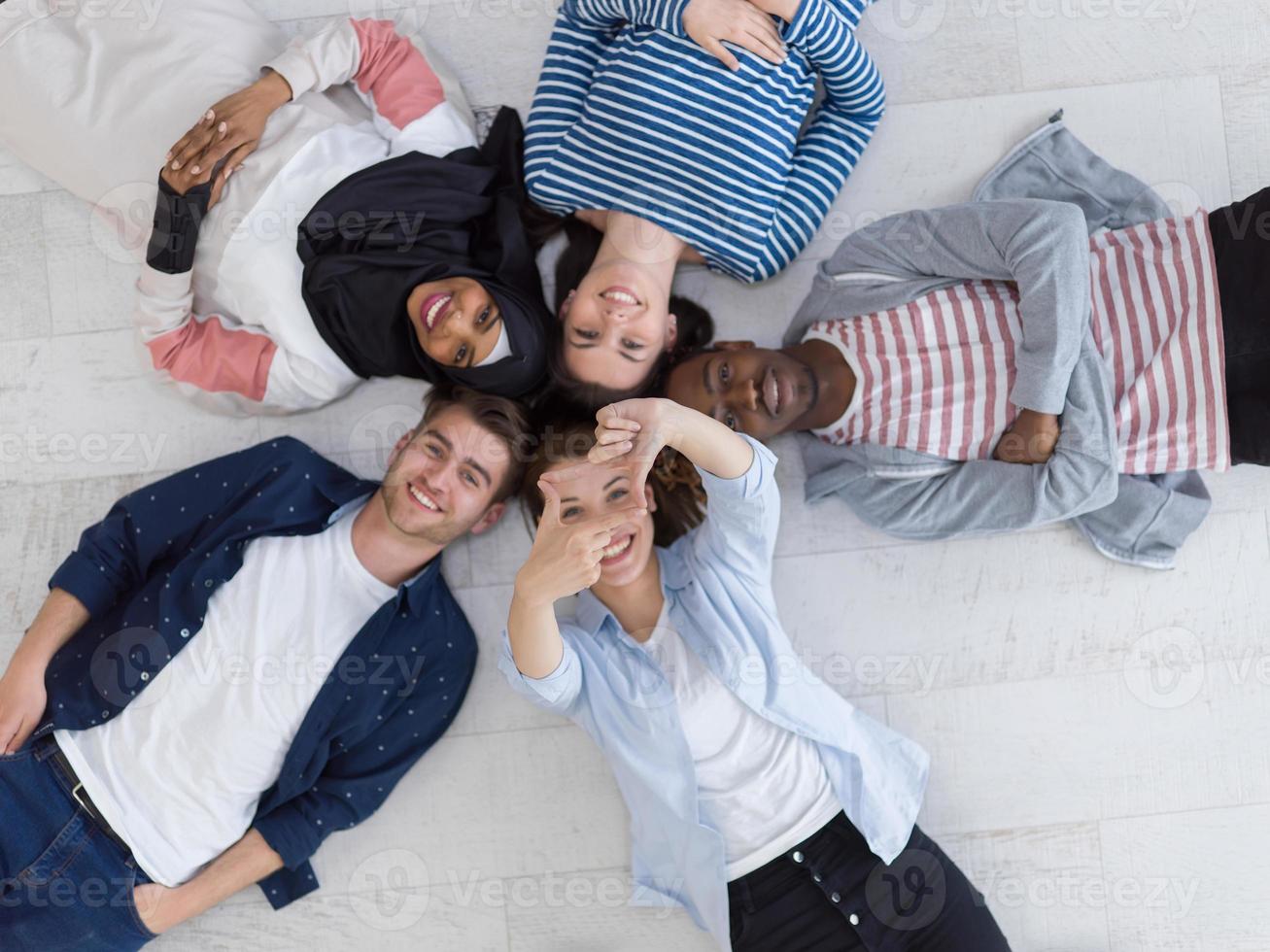 top view of a diverse group of people lying on the floor and symbolizing togetherness photo