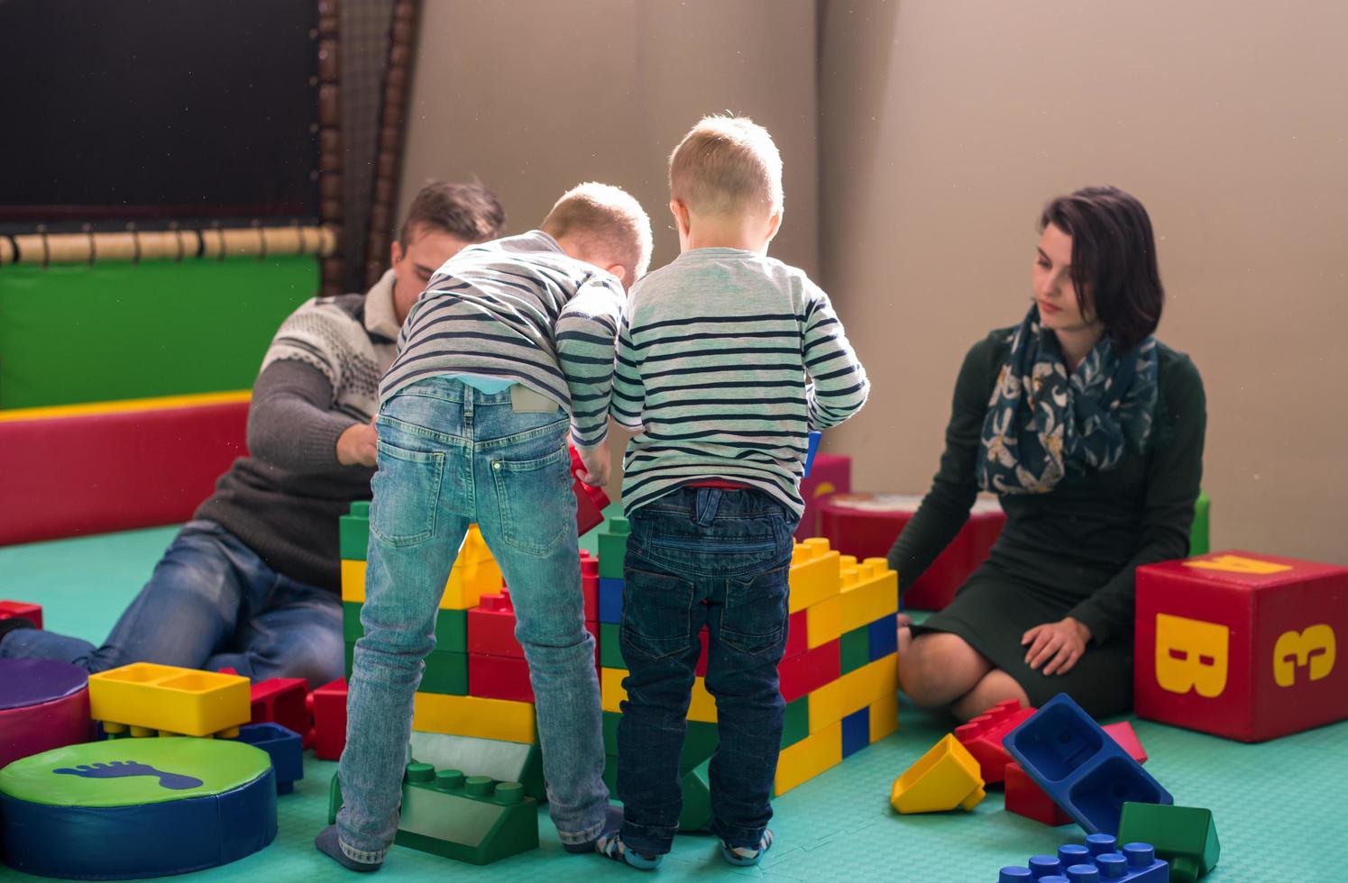 young parents and kids having fun at childrens playroom photo