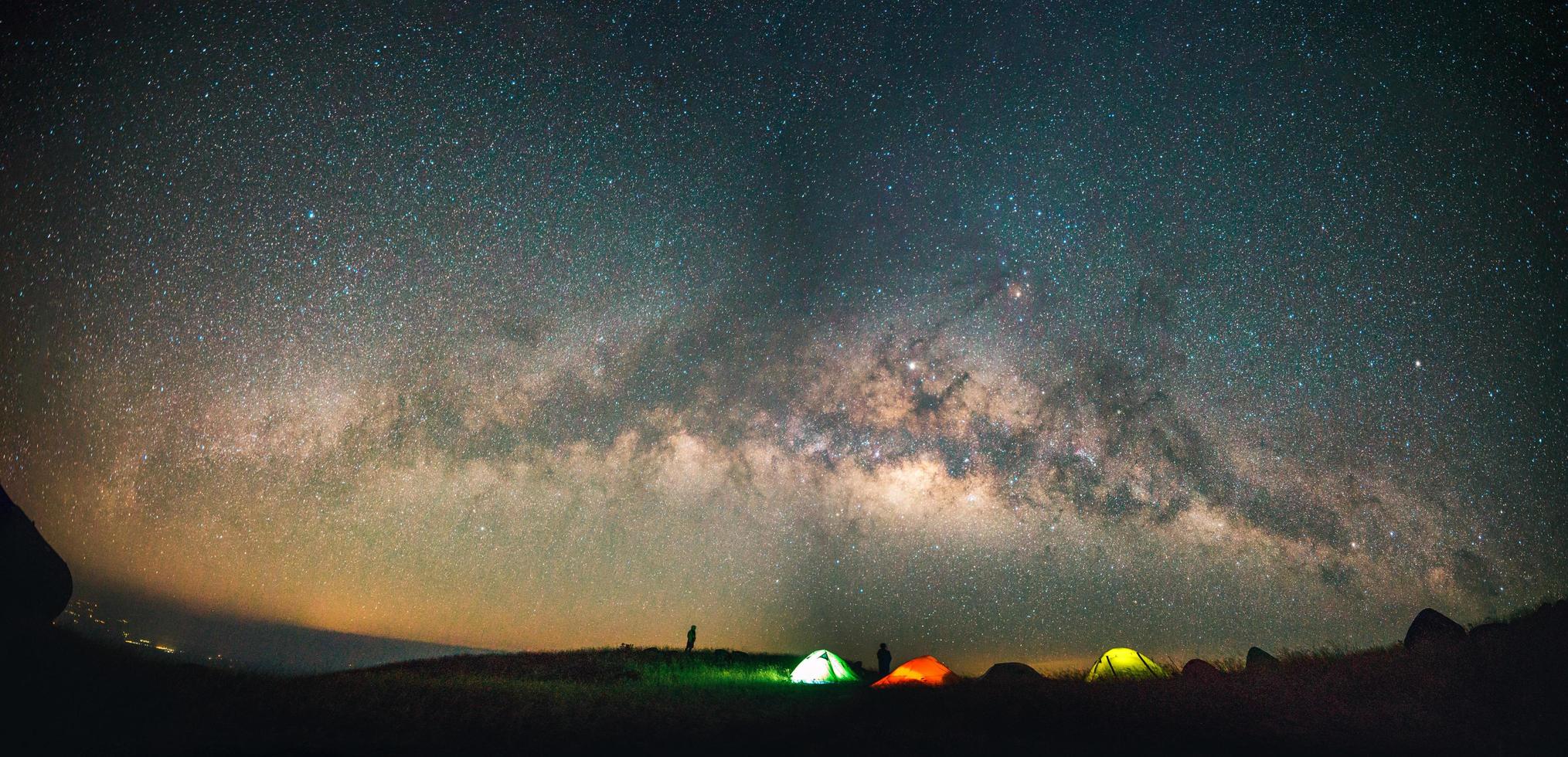 cielo nocturno azul oscuro con fondo espacial de la vía láctea estrella y silueta de un hombre feliz de pie foto