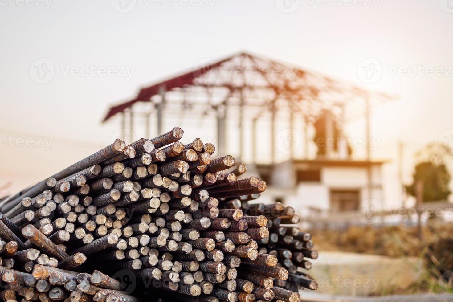 steel rebar for reinforcement concrete at construction site with house under construction background photo