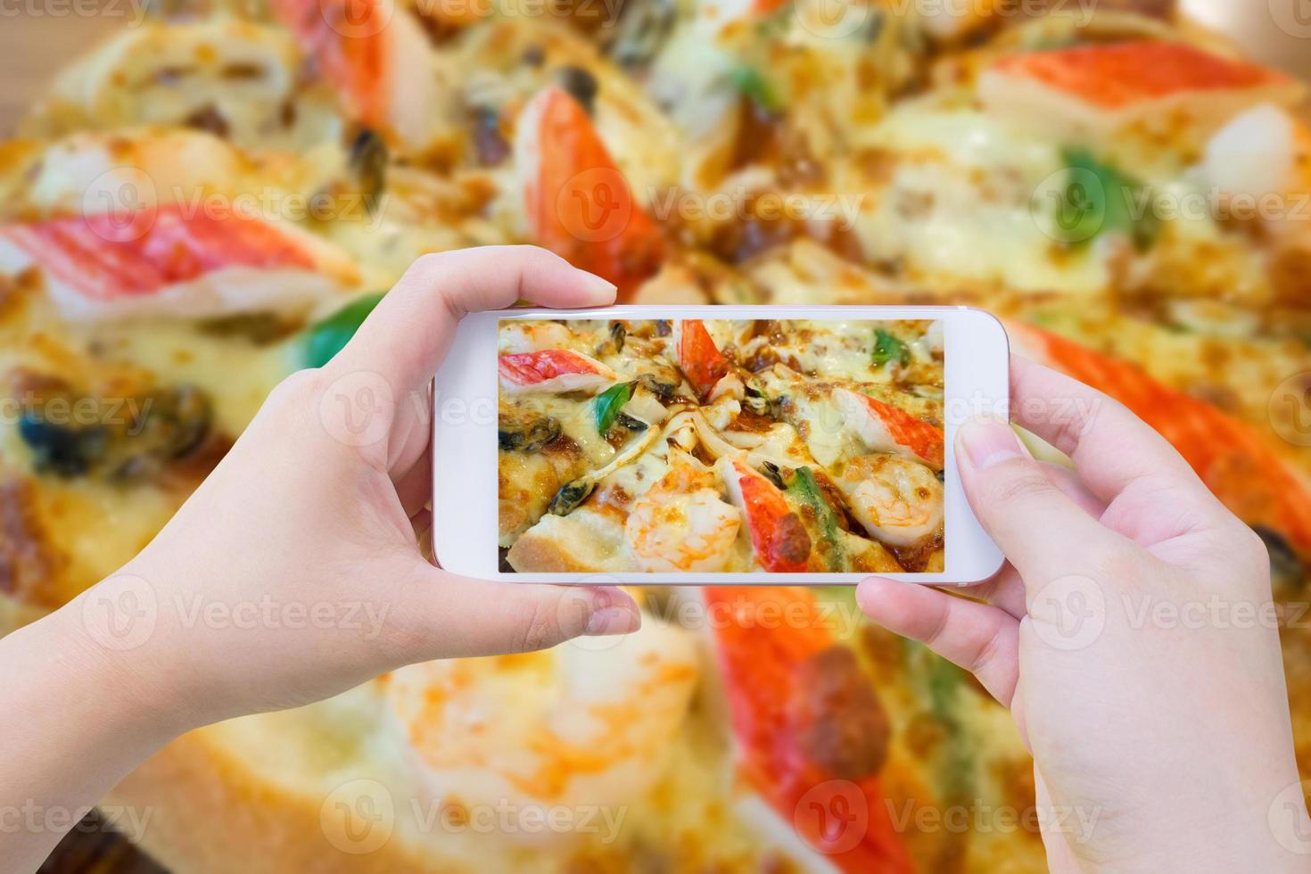 woman taking photo of Pizza and with mobile smartphone